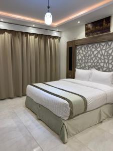 ein Schlafzimmer mit einem großen Bett in einem Zimmer in der Unterkunft دانة الفخامه للشقق الخدومة in Tabuk