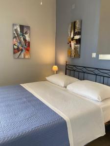 2 camas en una habitación con 2 pinturas en la pared en Daphne Bungalows, en Tolo