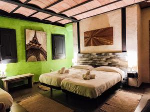 two beds in a room with green walls at Can Castell in Castellfollit de la Roca