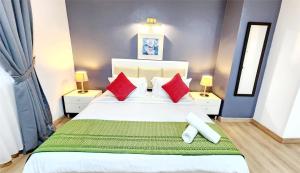 1 dormitorio con 1 cama blanca grande con almohadas rojas en Holiday Place Kuala Lumpur en Kuala Lumpur