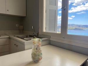 un jarrón en un mostrador en una cocina con ventana en Daphne Bungalows, en Tolo