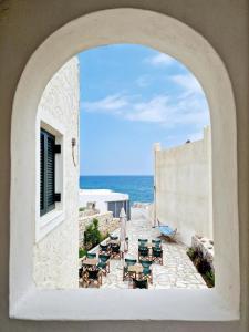 een boog met uitzicht op een patio met uitzicht op de oceaan bij Akti Apollona in Apollon