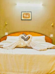 Eine Frau verkleidet in einem weißen Kleid auf einem Bett in der Unterkunft Hotel Tara Regency - A family Hotel in Shimla