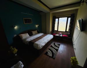 Hotel Tara Regency - A family Hotel في شيملا: غرفة نوم بسرير ونافذة