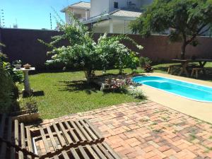 un patio trasero con piscina, mesa y banco en Pousada Canto das Estrelas, en Chapada dos Guimarães