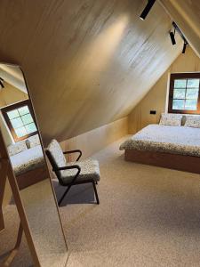 a bedroom with two beds and a mirror and a chair at Kur skamba varpai in Berżory