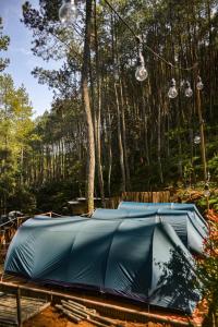 eine blaue Plane auf einem Tisch mit Bäumen im Hintergrund in der Unterkunft WULANDARI CAMPING GROUND in Bandung