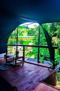 Zelt mit einem Tisch auf einer Holzterrasse in der Unterkunft WULANDARI CAMPING GROUND in Bandung