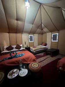 a room with two beds in a tent at Merzouga Paradise Luxury Camp in Merzouga