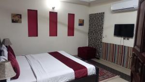 a bedroom with a bed and a flat screen tv at Elite Residence in Islamabad