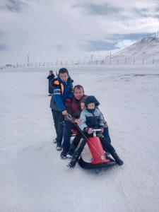 a family riding on a sled on the snow at Çiftlik otel 