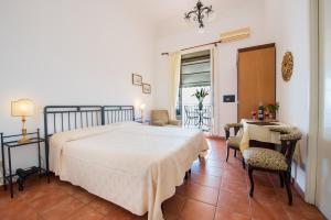 1 dormitorio con 1 cama, mesa y sillas en Hotel Bel Soggiorno, en Taormina