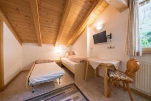a small room with a bed and a desk at Gasthof Innerwalten in San Leonardo in Passiria