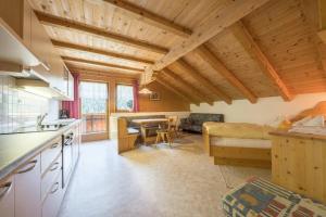 a kitchen and living room with wooden ceilings at Gasthof Innerwalten in San Leonardo in Passiria