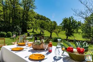 a table with plates of food and a basket of vegetables at La Métairie La Maison de Ninette in Castelculier