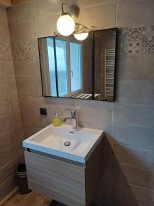 a bathroom with a sink and a mirror at Gîte in Ganges