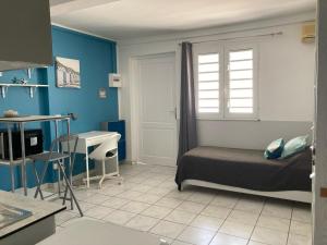 Schlafzimmer mit einem Bett, einem Fenster und einem Waschbecken in der Unterkunft Chaleureux Studios Martinique in Fort-de-France