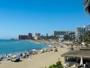 a group of people on a beach with the ocean at Victoria luxury beachfront apartment in Benalmadena Costa in Benalmádena