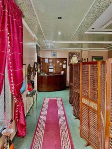 een kamer met rode gordijnen en een rode loper bij Sary's Hotel in M'diq