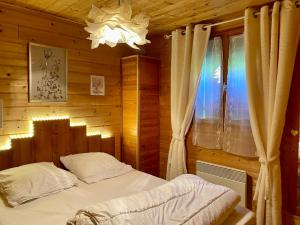 - une chambre avec un lit dans une pièce en bois dans l'établissement Chalet des Moineaux, à Saint-Laurent-du-Jura