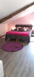 a bedroom with a large bed with a purple blanket at A Larriou in Mirepoix