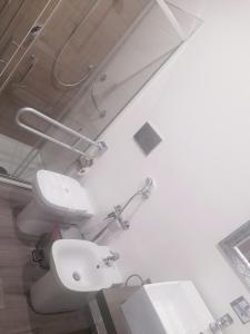 a white bathroom with a toilet and a sink at White House & B. in Sìnnai