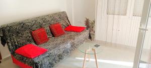 a living room with a couch with red pillows at Candy Studio Apt Marousi in Athens