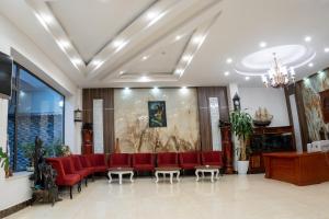 a waiting room with red chairs and a couch at Mai Khanh Hotel in Da Lat