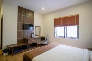 a bedroom with a bed and a desk with a computer at Mai Khanh Hotel in Da Lat