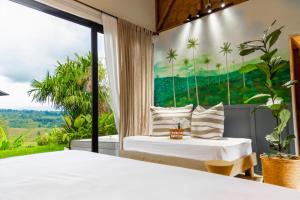 two beds in a room with a large window at Ecohotel Monte Tierra Habitaciones y Glamping in Filandia