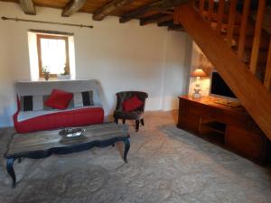 a living room with a red couch and a television at Domaine de Nineyrolle in Azerat