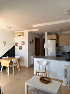 a kitchen and living room with a table and chairs at Appartement N618 avec solarium sur golf resort in Alhama de Murcia