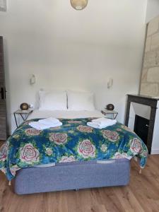 a bed with a blue comforter with two towels on it at Maison typique bordelaise in Bordeaux