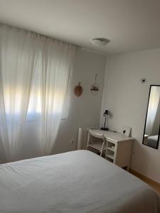a bedroom with a bed and a desk and a window at Appartement N618 avec solarium sur golf resort in Alhama de Murcia +23 photos