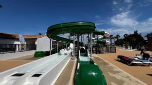 a green slide at a water park at Mobil homme proche de la mer in Le Grau-du-Roi