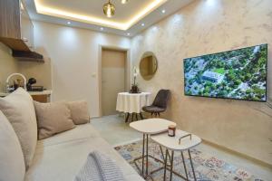 un soggiorno con divano e TV a parete di Vila Apartments Lidija a Petrovac na Moru