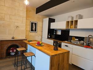 a kitchen with white cabinets and a fireplace at Maison typique bordelaise in Bordeaux