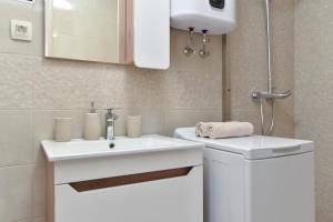 佩特羅瓦納莫魯的住宿－Vila Apartments Lidija，浴室配有白色水槽和卫生间。