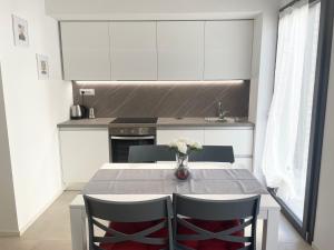 a kitchen with a table with chairs and a vase of flowers at MP home in Le Grazie