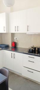 a kitchen with white cabinets and a red appliance at Candy Studio Apt Marousi in Athens