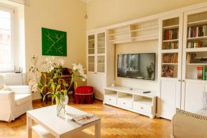 a living room with white cabinets and a tv at Luxury Borghese Magnolia Suite in Rome