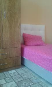 a bedroom with a pink bed and a wooden cabinet at Çiftlik otel 