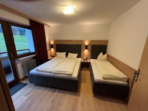 a hotel room with two beds and a window at Appartement Gästehaus Aloisia in Hippach