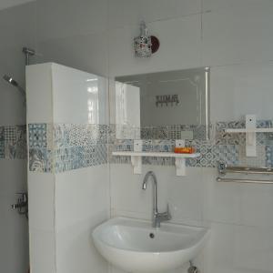 ein weißes Badezimmer mit einem Waschbecken und einem Spiegel in der Unterkunft desert pearl beautiful cosy new home in Luxor