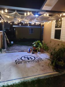 a backyard at night with lights and a patio at The Surada Bay 2 bedrooms in Old Harbour