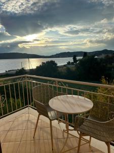 una mesa y sillas en un balcón con vistas al agua en Evita Beach Hotel, en Spilia