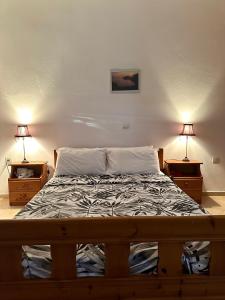 1 cama en un dormitorio con 2 mesitas de noche y 2 lámparas en Evita Beach Hotel, en Spilia
