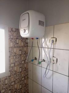 a bathroom with a blow dryer on the wall at Comfort Zone Apartment in Yaoundé