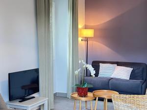 een woonkamer met een bank en een tv bij Gîtes Château de la Selve in Grospierres