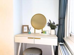 a dressing table with a mirror on top of it at Broomsleigh NW6 Apartment in London